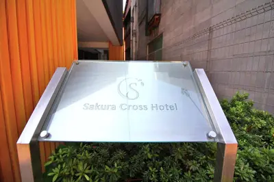 a sign for a sakura cross hotel in front of a building at Sakura Cross Hotel Ueno Iriya in Tokyo