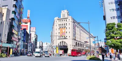 a busy city street with cars and buses at Sakura Cross Hotel Ueno Iriya in Tokyo