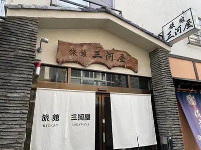 a building with a sign on the side of it at Ryokan Mikawaya in Tokyo