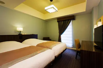 a hotel room with two beds and a window at Hotel Monterey Hanzomon in Tokyo