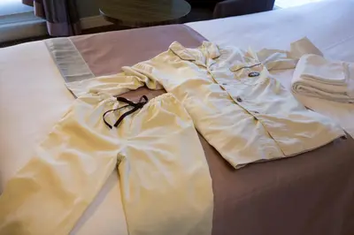 a pile of clothes sitting on a bed at Hotel Monterey Hanzomon in Tokyo