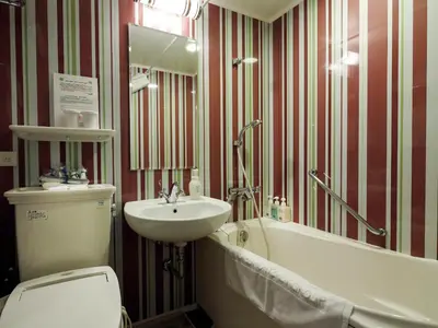 a bathroom with a sink and a toilet and a tub at Hotel Monterey Hanzomon in Tokyo