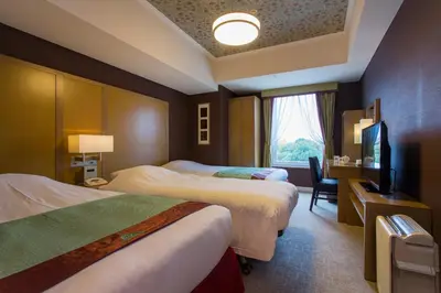 a hotel room with two beds and a television at Hotel Monterey Akasaka in Tokyo