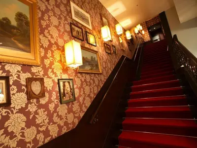 a staircase in a building with pictures on the wall at Hotel Monterey Akasaka in Tokyo
