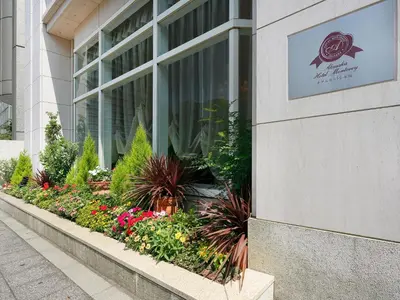 a sign on the side of a building with flowers at Hotel Monterey Akasaka in Tokyo