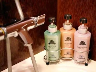 three bottles of soap sitting on top of a sink at Hotel Monterey Akasaka in Tokyo