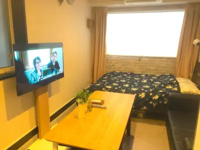 a room with a bed and a television on a wall at Tokyo Art House in Tokyo