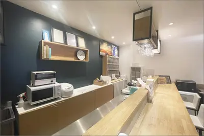 a waiting room with a counter with a microwave and a tv at &AND HOSTEL AKIHABARA in Tokyo