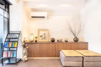 a living room with a couch and a shelf at Nihonbashi Kakigara Ryokan in Tokyo