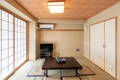 a living room with a table and a tv at Nihonbashi Kakigara Ryokan in Tokyo