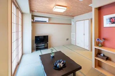a living room with a table and a tv at Nihonbashi Kakigara Ryokan in Tokyo