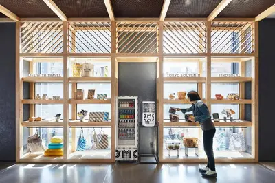 a woman standing in a store looking into a shop window at OMO5 Tokyo Otsuka by Hoshino Resorts in Tokyo
