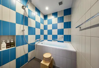 a blue and white bathroom with a tub and a shower at OMO5 Tokyo Otsuka by Hoshino Resorts in Tokyo