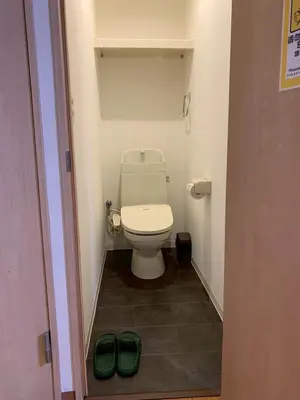 a bathroom with a toilet and a pair of green shoes at HOTEL PRELE Asakusa \u30db\u30c6\u30eb\u30d7\u30ec\u30fc\u30eb\u6d45\u8349 in Tokyo