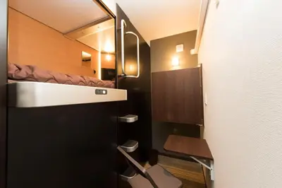 a small bathroom with a bed in a small room at Ryoma Ikebukuro in Tokyo