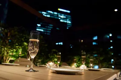 two glasses of champagne sitting on a table with a city skyline at Turn Table in Tokyo