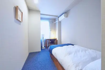 a small bedroom with a bed and a window at Turn Table in Tokyo