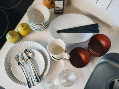 a table topped with white plates and cups and utensils at MIMARU Tokyo Akasaka in Tokyo
