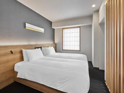 a bedroom with a bed with white sheets and a window at MIMARU Tokyo Akasaka in Tokyo