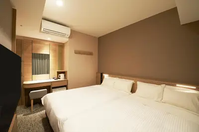 a bedroom with a large white bed and a desk at Sotetsu Fresa Inn Tokyo Kanda in Tokyo