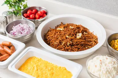 a table with bowls of food and other dishes at Sotetsu Fresa Inn Tokyo Kanda in Tokyo