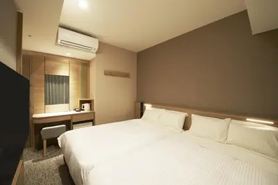 a bedroom with a large white bed and a desk at Sotetsu Fresa Inn Tokyo Kanda in Tokyo
