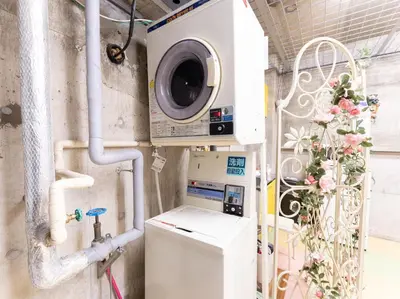 a washer and dryer in a room with pipes at Chang Tee Hotel Ikebukuro in Tokyo