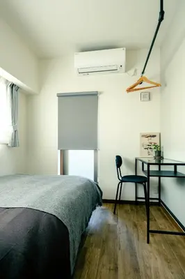 a bedroom with a bed and a desk and a window at Home n Lounge in Tokyo