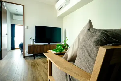 a living room with a couch and a flat screen tv at Home n Lounge in Tokyo