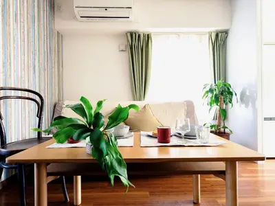 a living room with a wooden table with a plant on it at City Hideout in Tokyo
