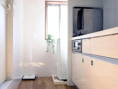 a kitchen with a tv and a sliding glass door at City Hideout in Tokyo