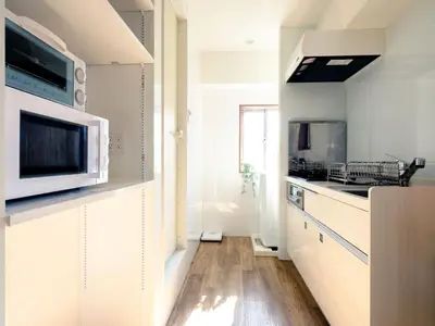a kitchen with white cabinets and a microwave at City Hideout in Tokyo