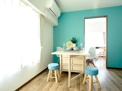 a dining room with blue walls and a table and stools at City Hideout in Tokyo