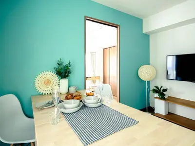 a dining room with a table and a blue wall at City Hideout in Tokyo