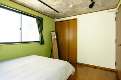 a bedroom with a bed and a window at Ikken House in Tokyo