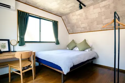 a bedroom with a bed and a desk and a chair at Ikken House in Tokyo