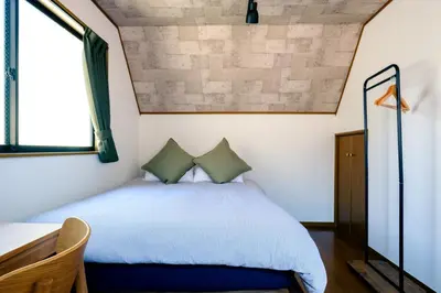 a bedroom with a bed and a window at Ikken House in Tokyo