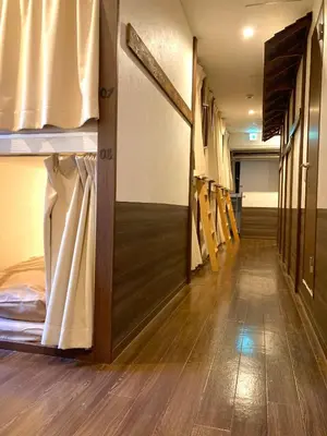 a room with bunk beds and a hallway with wood floors at bnb+ Shinbashi in Tokyo