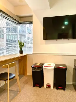 a room with two trash cans and a tv at bnb+ Shinbashi in Tokyo