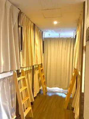 a room with two chairs and a window with curtains at bnb+ Shinbashi in Tokyo