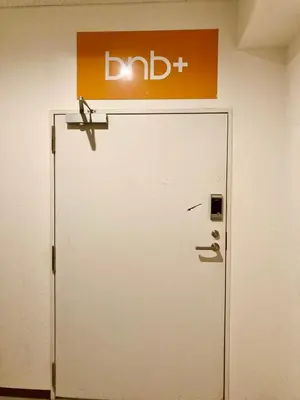 a white door with a sign on top of it at bnb+ Shinbashi in Tokyo