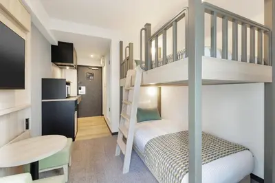 a small room with a bunk bed and a desk at HOTEL MYSTAYS Nippori in Tokyo