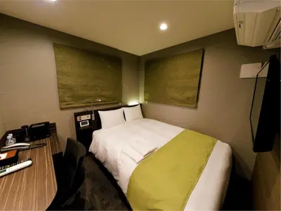 a small room with a bed and a desk with a desk at Act Hotel Roppongi in Tokyo