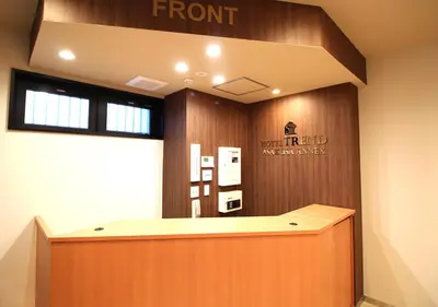 a front desk in a office with a sign on the wall at Hotel Trend Asakusa Annex in Tokyo