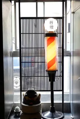 a lamp on a table in front of a window at Andon Ryokan in Tokyo