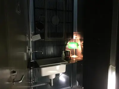a bathroom with a sink and a green lamp at Andon Ryokan in Tokyo