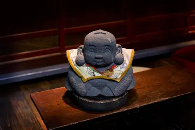a statue of a monk sitting on a table at Andon Ryokan in Tokyo