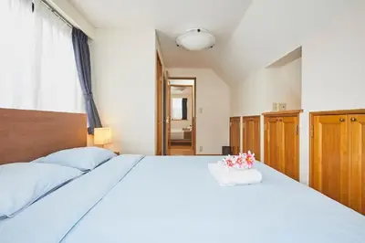 a bedroom with a large white bed with flowers on it at F1-Upmarket Huose in Shinjuku in Tokyo