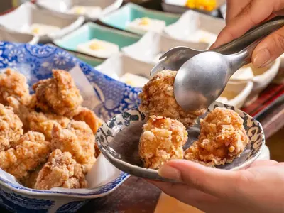 a person holding a spoon and a bowl of food at APA Hotel Nihombashi Bakurocho Ekikita in Tokyo