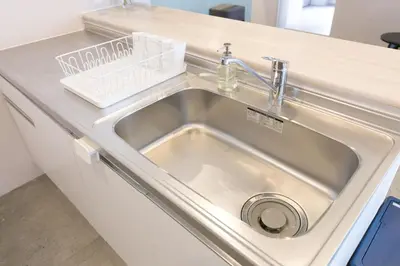 a stainless steel sink in a kitchen counter at hostel DEN in Tokyo